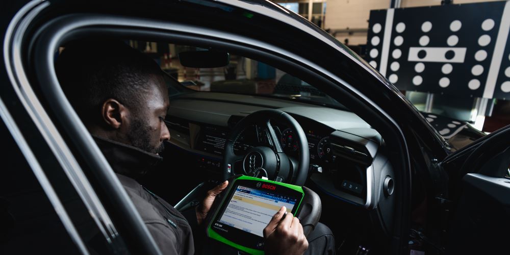 Kwik Fit technician using Bosch KTS350 to calibrate ADAS