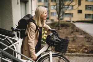 woman carrying a push bike