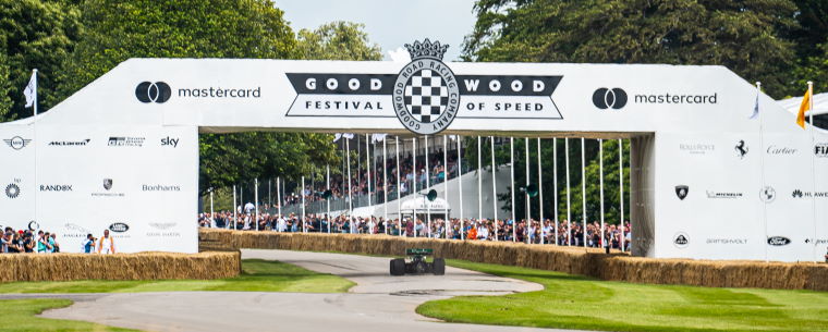 F1 Car Passing Beneath Goodwood FoS Sign