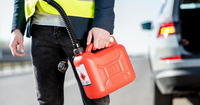 man holding jerry can walking away from car