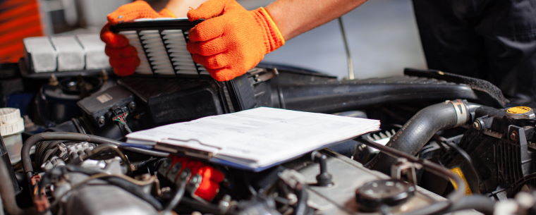 Mechanic servicing car under bonnet