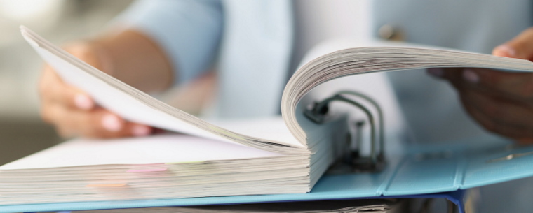 Person reading paperwork in a ring bound folder