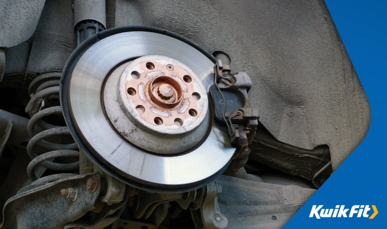 A brake disc and brake pad on a car.